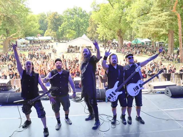 The band posing on stage with the festival crowd behind