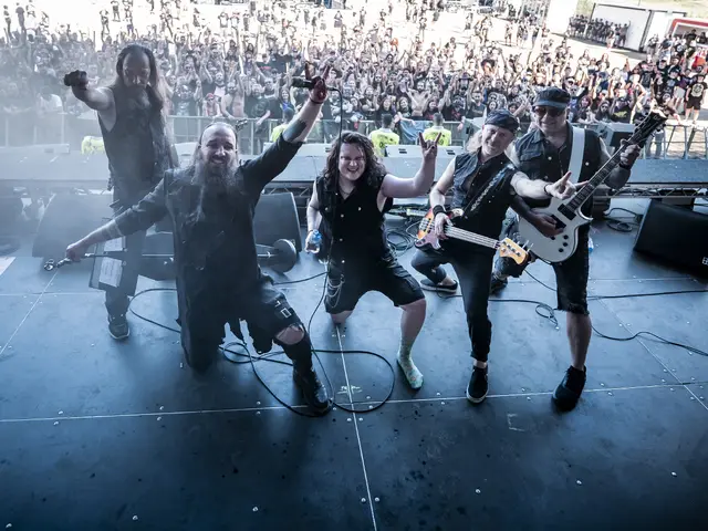 The whole band at the stage edge with the packed festival crowd behind